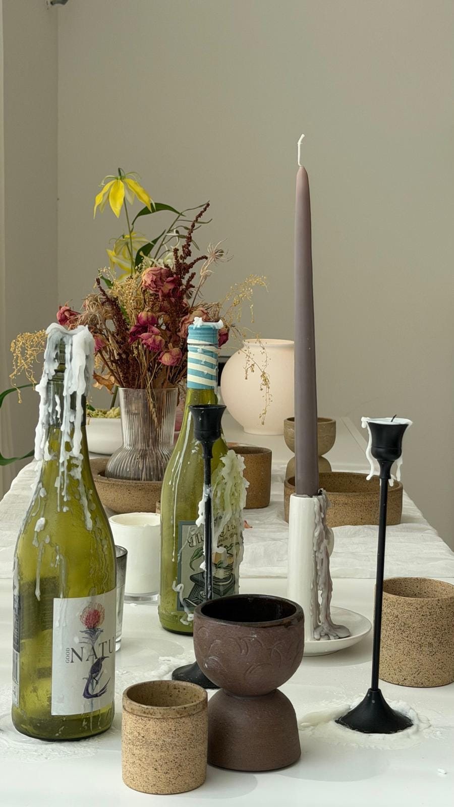 Candlelit table at ROA Art studio with dried flowers, tapered candles and handmade ceramic cups