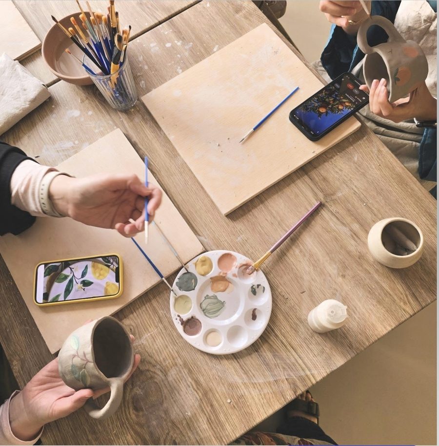 Ceramic painting workshop table with brushes, palettes and bisque pieces